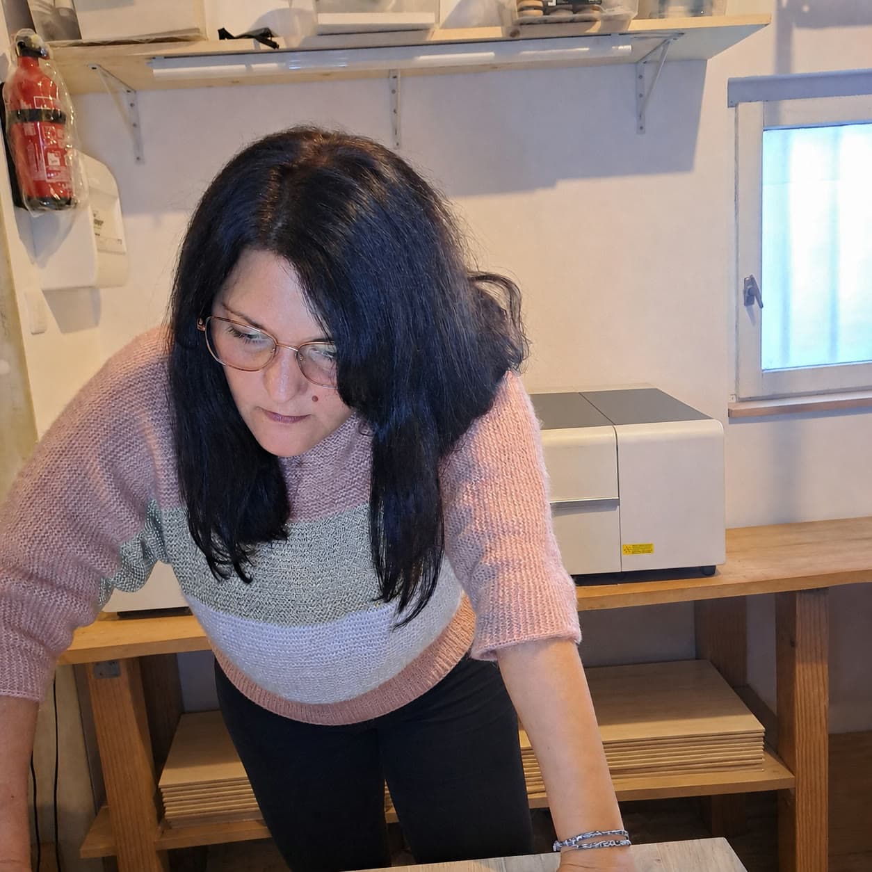 Orianne au travail dans son atelier, penchée sur son plan de travail